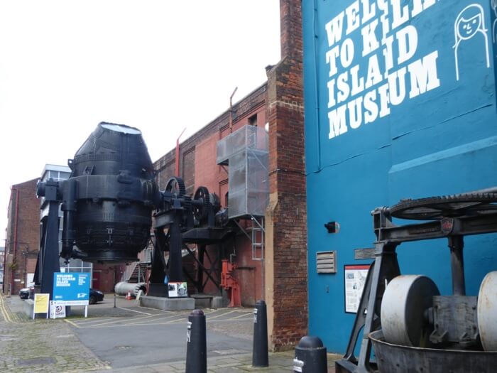 A towering Bessemer converter outside an old warehouse that has been converted into a museum
